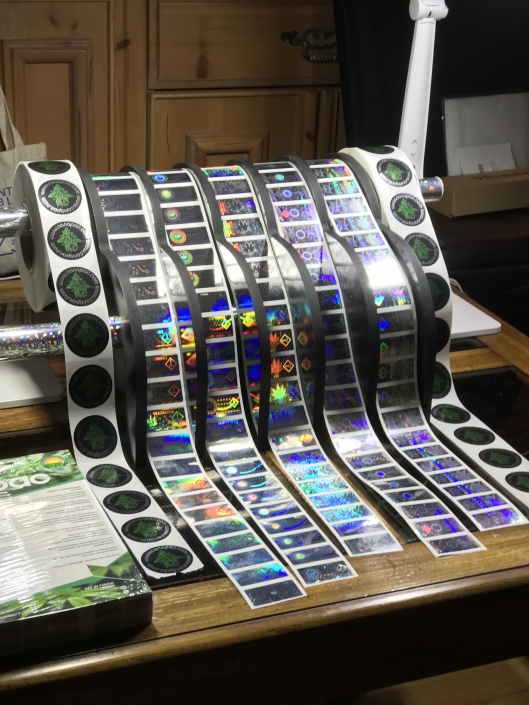 Trade show display rack in 2019 we decided to build a custom rack to hold our canapac labels to best view them. We had our friends over at Lasercam cut us this custom shaped display to best showcase our holographic labels.